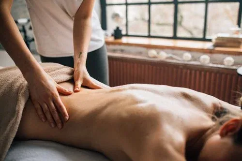 A therapist applying focused pressure to a client’s back