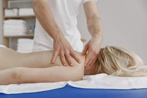 A therapist giving a relaxing shoulder and back massage to a woman